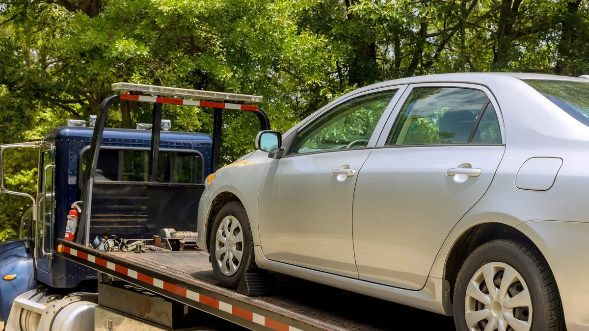 Car loaded on the deck of a tow truck — Illinois Tow Trucking Insurance from Truck Guard Insurance