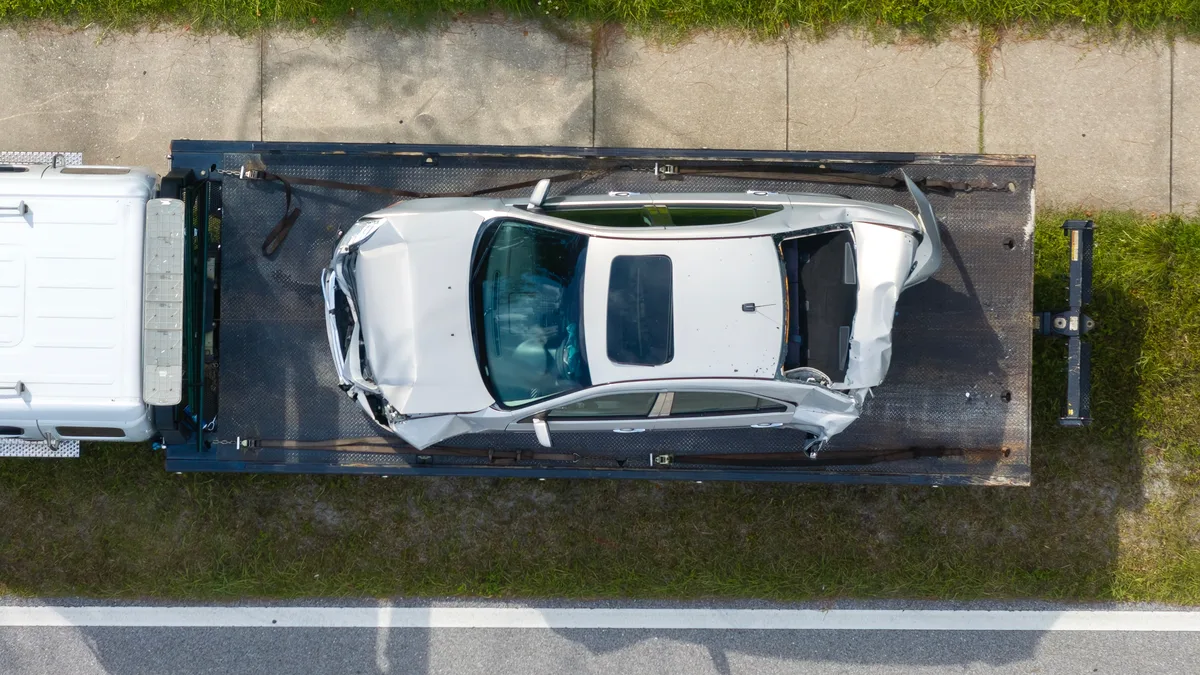 Aerial view of a damaged car on a tow truck deck — Ohio Tow Trucking Insurance from Truck Guard Insurance